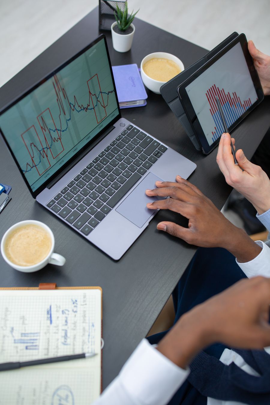 Colleagues reviewing sales charts on a laptop and a tablet