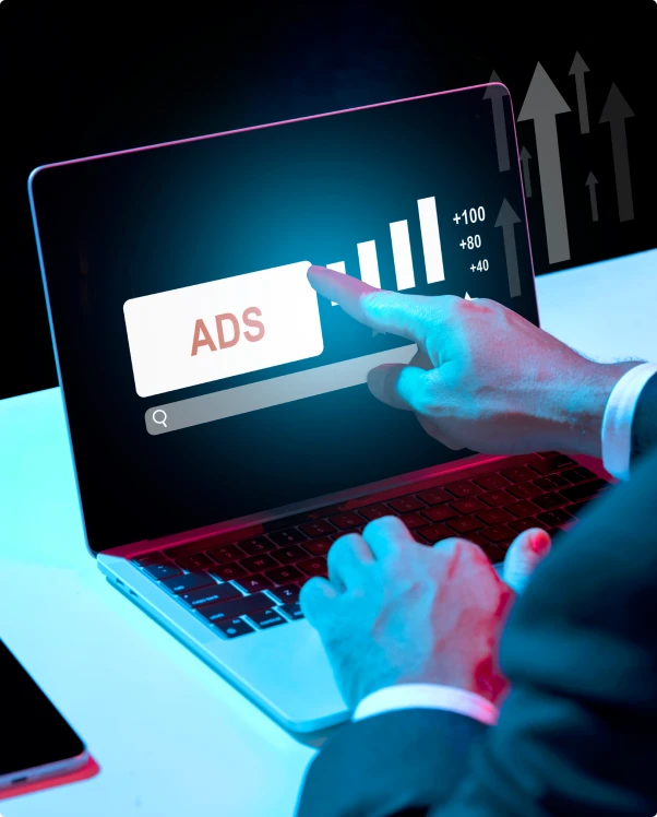 Finger tapping an ADS button on a laptop screen beside rising bar charts