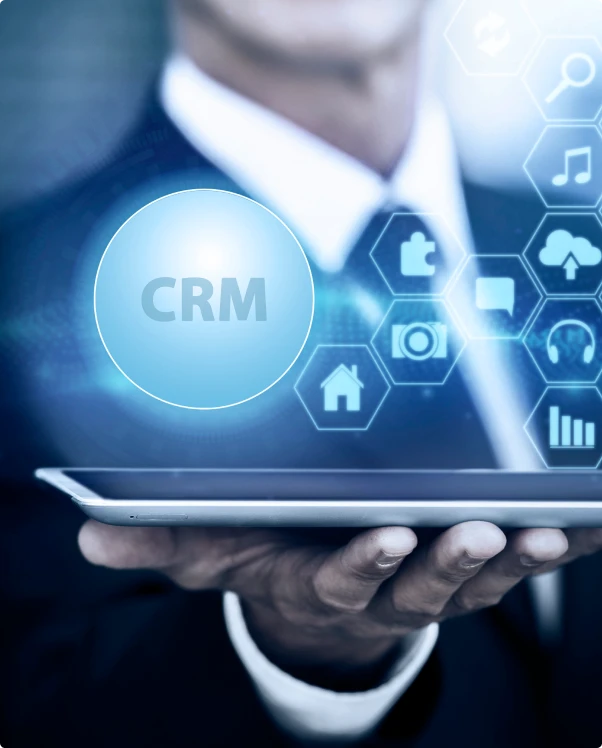Businessman holding a tablet under a CRM hologram and app icons