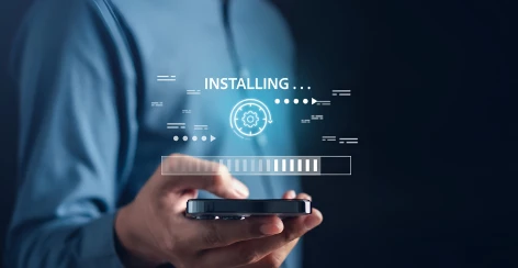 A hand holding a smartphone while an app installs