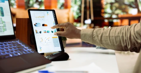 Person tapping a reporting dashboard on a tablet