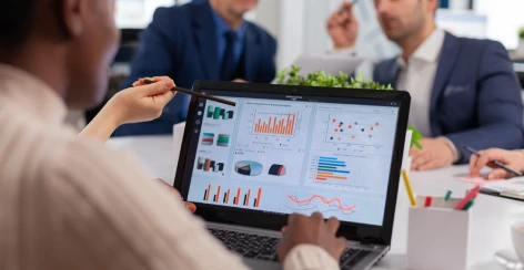 A team reviewing sales charts on a laptop during a meeting