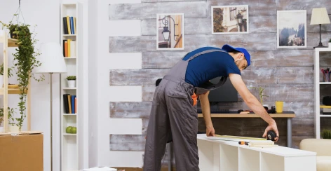 Contractor measuring and installing shelving in a home