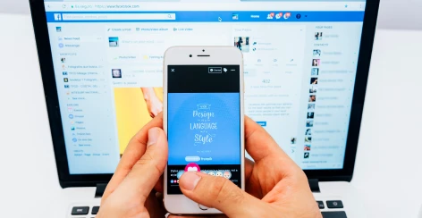 Facebook feed open on a laptop and phone