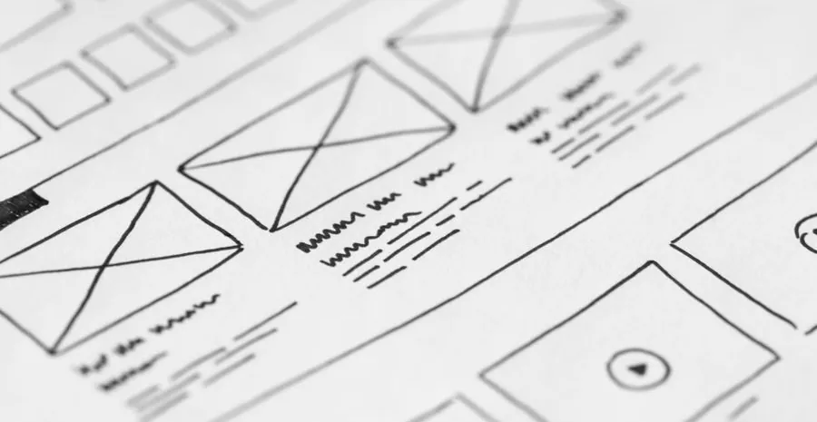 Hand-drawn web page layout wireframes sketched on paper