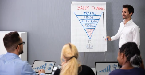 Presenter explaining a sales funnel chart to a team