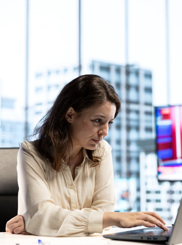 Woman working on a laptop in a bright office