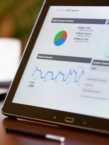 Tablet showing a traffic sources pie chart and a visitors trend line