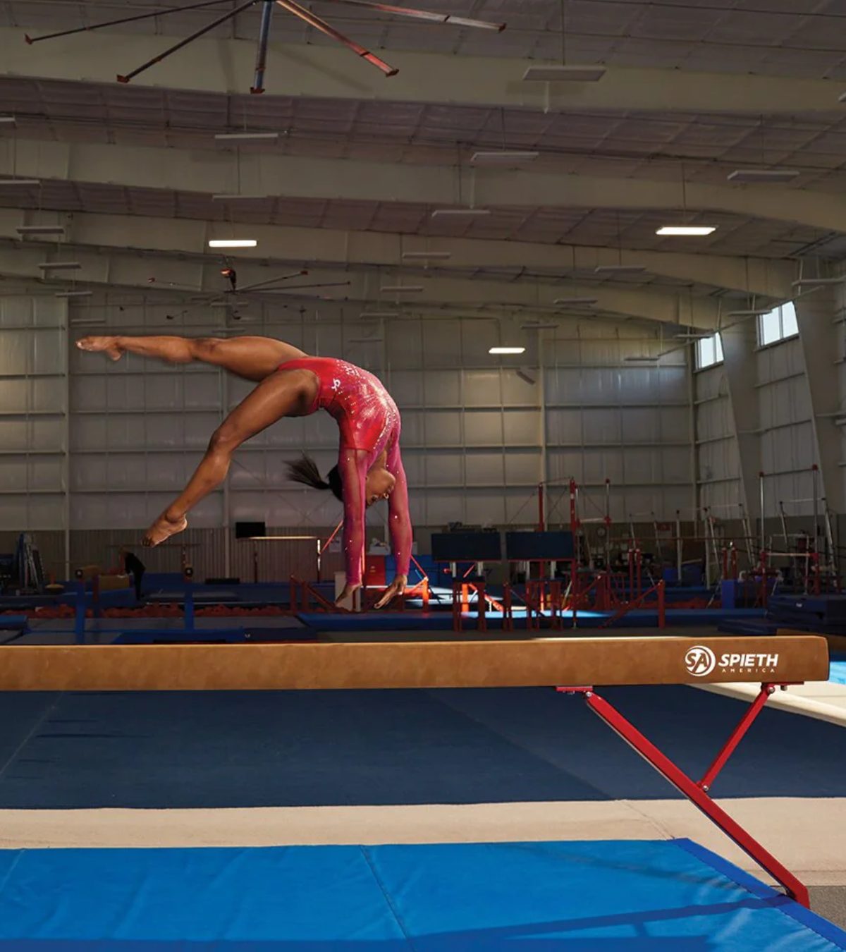 Gymnast on a balance beam in a training gym